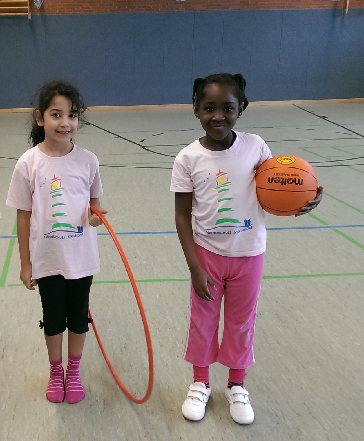 Zwei Mädchen mit einem Reifen und einem Basketball