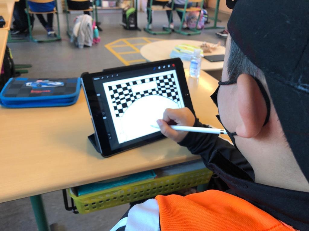 Ein Kind malt mit einem Stift auf einem Tablet-PC.